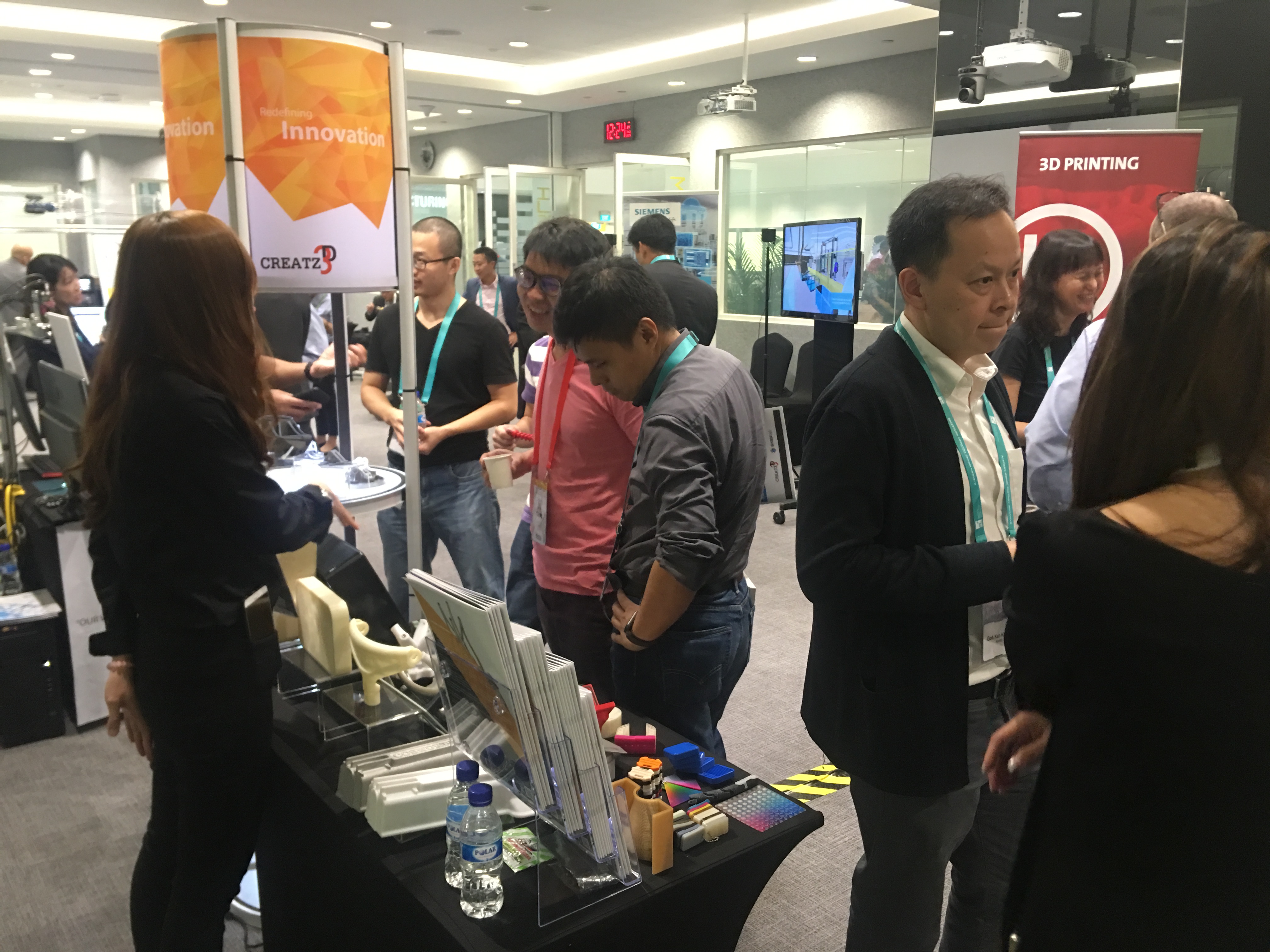Visitors learning about 3D printing solutions at Creatz3D's booth at ARTC Model Factory launch event