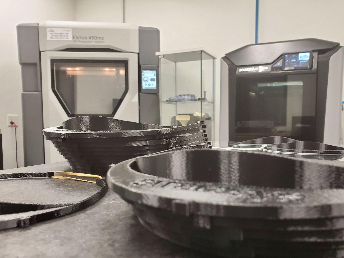 Stratasys FDM 3D printers (background) at Don Schumacher Racing are operating 24 hours a day to produce headbands for medical face shields.